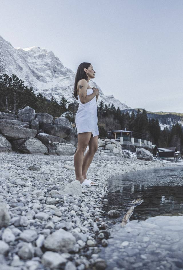 Frau im Winter im Handtuch blickt auf den Eibsee