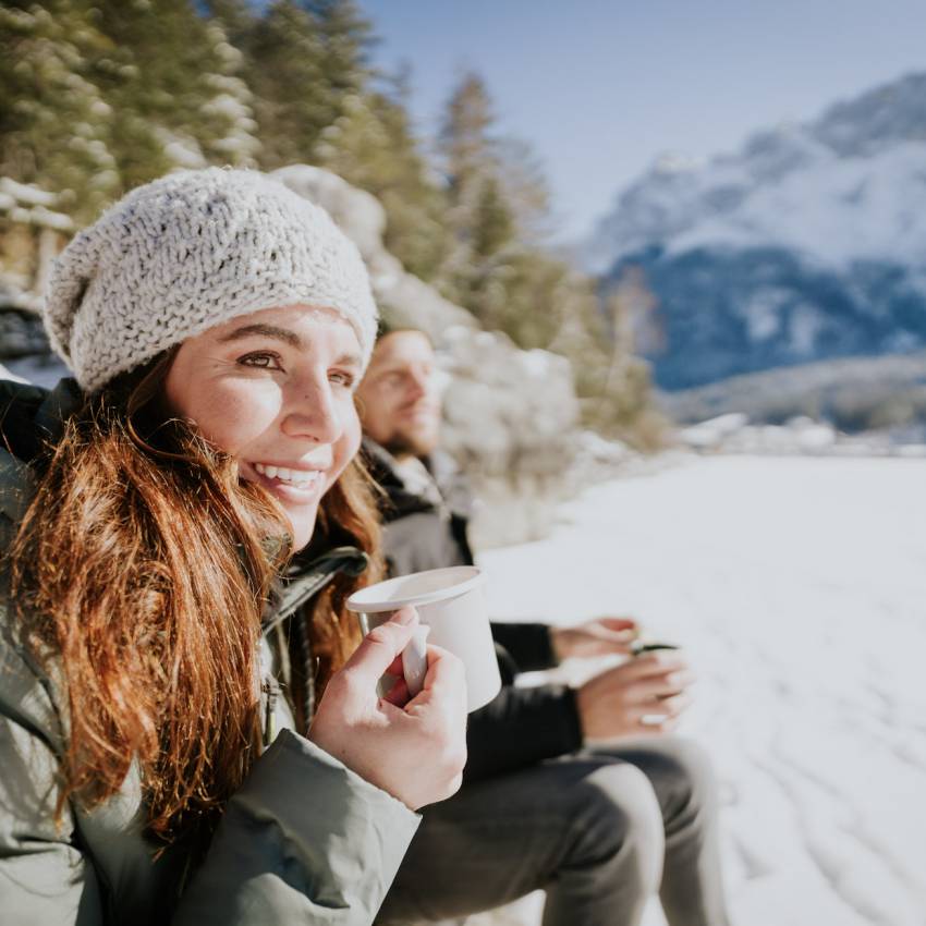 Frau und Mann mit Tee im Schnee am Eibsee