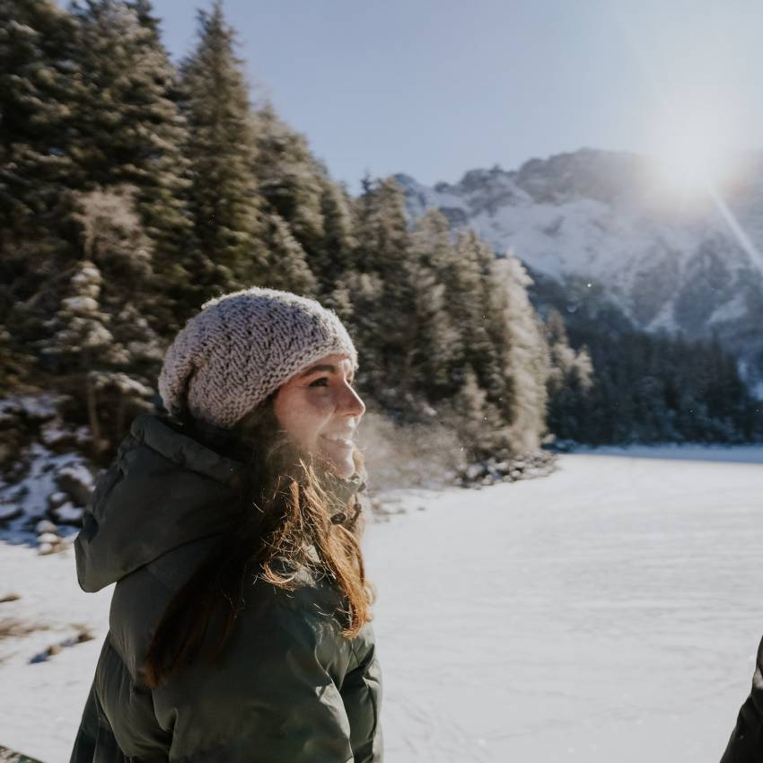 Frau im Winter blickt auf den Eibsee