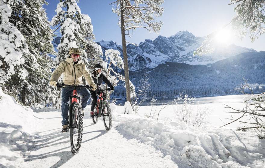 Man und Frau beim Winterbiken am Eibsee